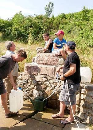 Trinkwasserquelle mit neugierigen Buben ...