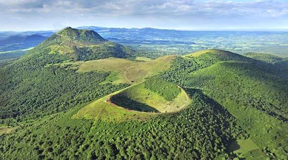 Leuchtender Vulkankrater auf Werbeprospekten, hinten Puy-de-Dom ... Leuchtender Vulkankrater auf Werbeprospekten, hinten Puy-de-Dom ...