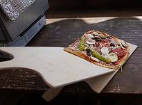 So bringt man die rohe Pizza vom Brett auf den Stein ...